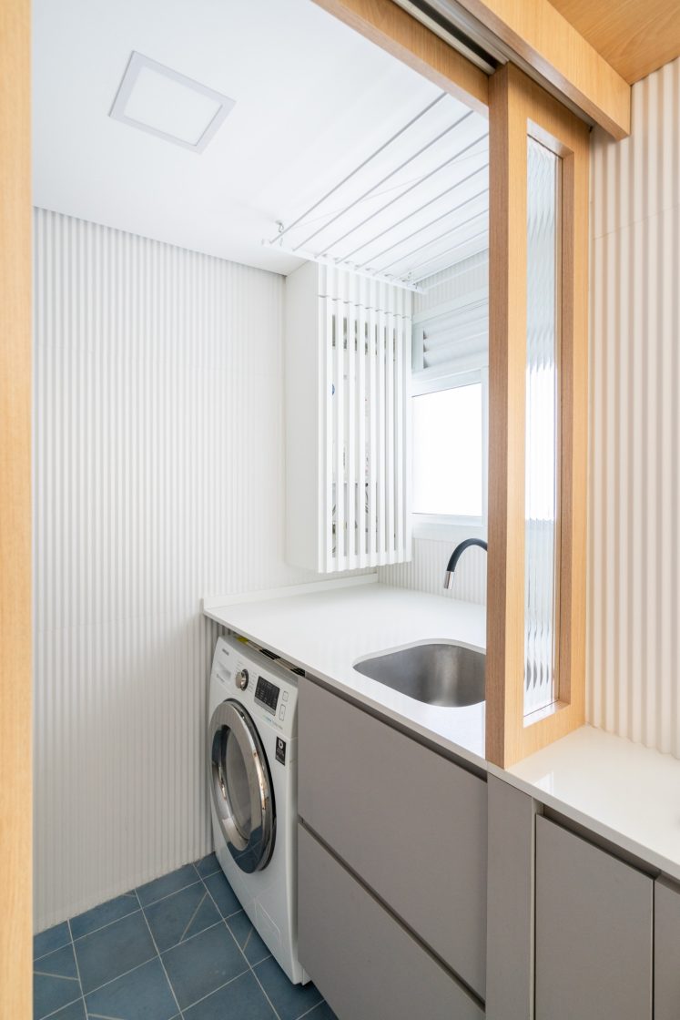 lavanderia simples com marcenaria cinza e bancada branca e piso azul 