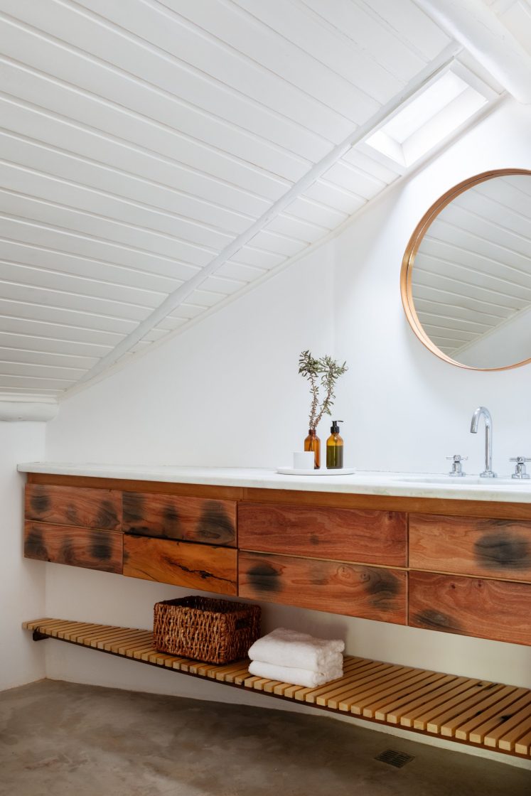 banheiro com armário de madeira e espelho redondo 