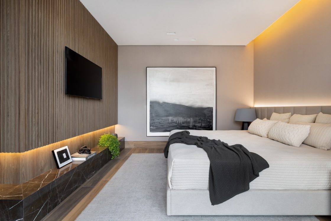 quarto minimalista com paredes bege, cama e parede com porcelanato que interpreta madeira 