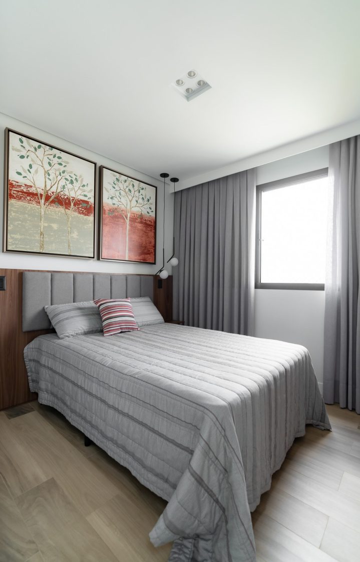 quarto minimalista com roupa de cama cinza e dois quadros de flores na parede