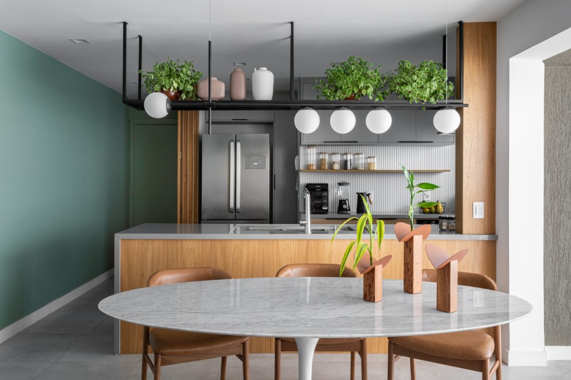 Cozinha integrada com sala de jantar com parede verde e em madeira