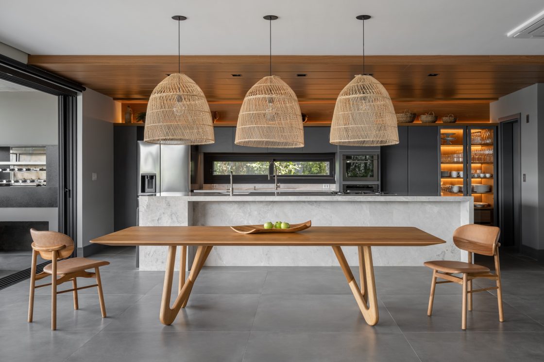Cozinha integrada com área gourmet com ilha espaçosa em mármore claro