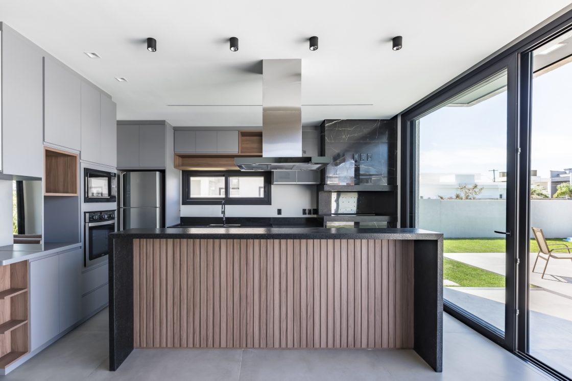 Cozinha moderna com ilha balcão decorada com lambri de madeira