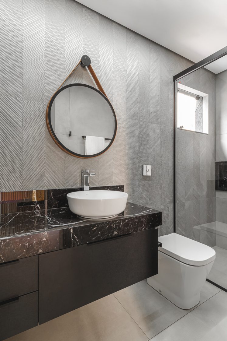 Banheiro moderno com paredes texturizadas em tons de branco, preto e cinza