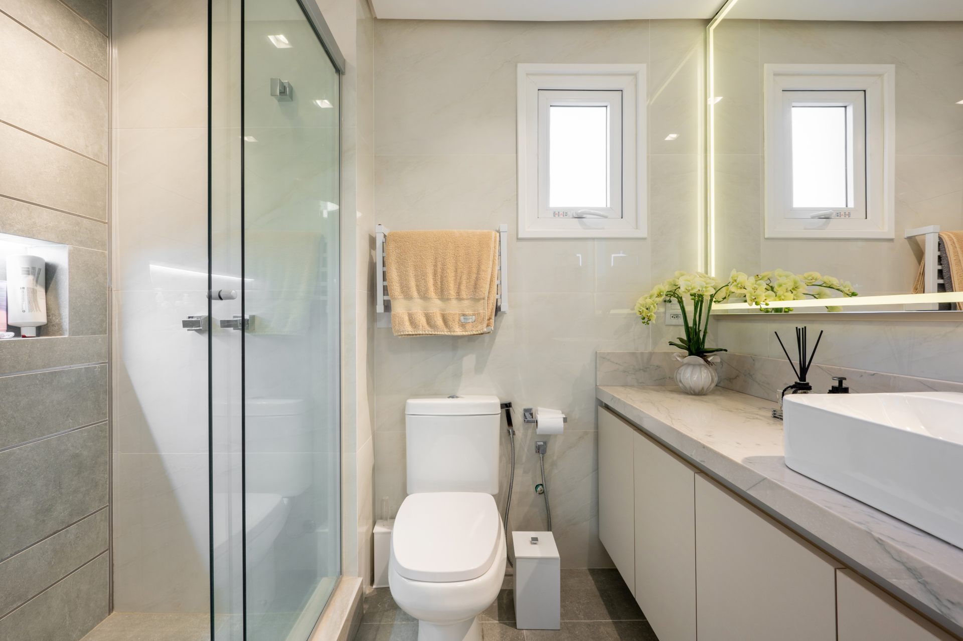Banheiro simples em tons claros, toalheiro térmico branco