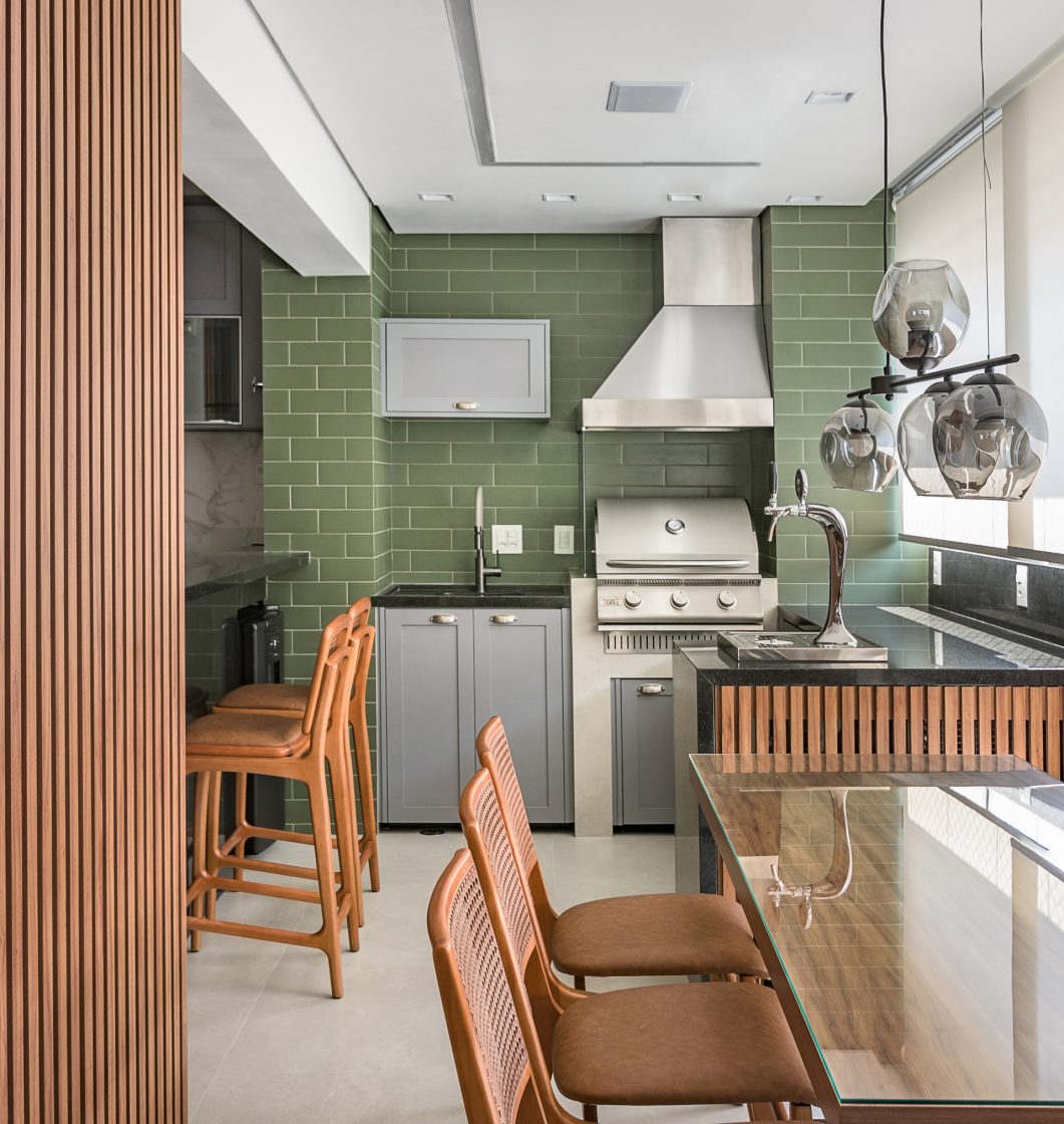 Cozinha gourmet verde com madeira e armário cinza, eletros em inox