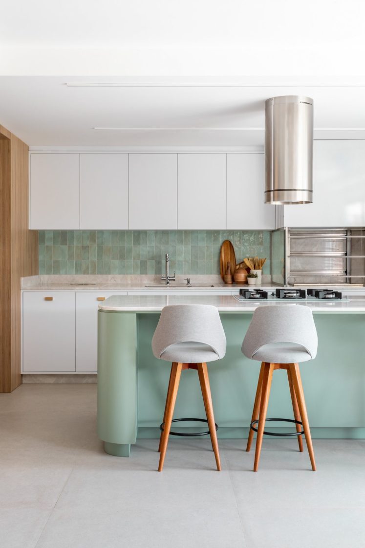 Cozinha integrada com marcenaria branca e backsplash verde