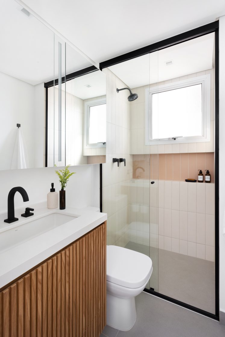Banheiro branco com gabinete em madeira e nicho com azulejo colorido