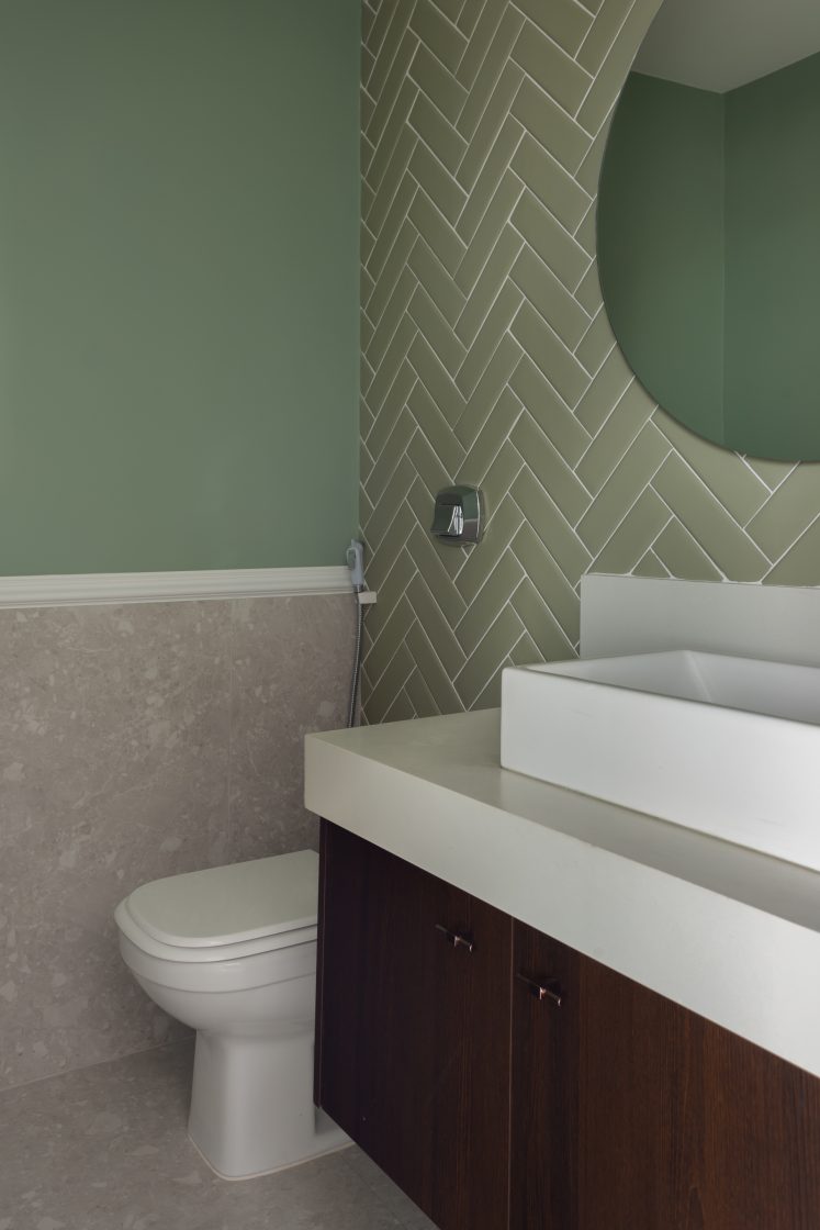 Banheiro com paredes em verde destaque para o trabalho com azulejos
