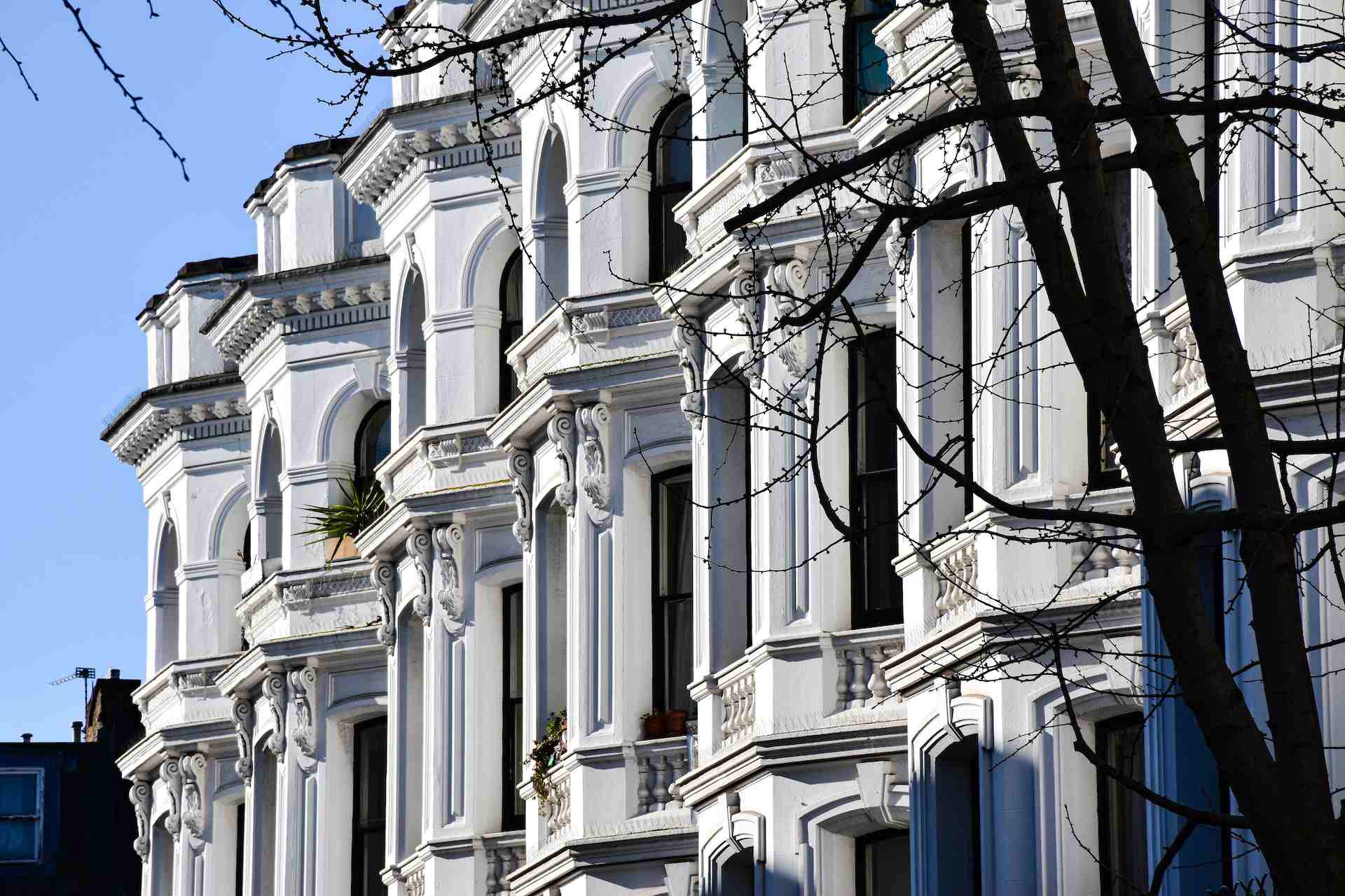 Várias casas vitorianas, brancas e ornamentadas, lado a lado