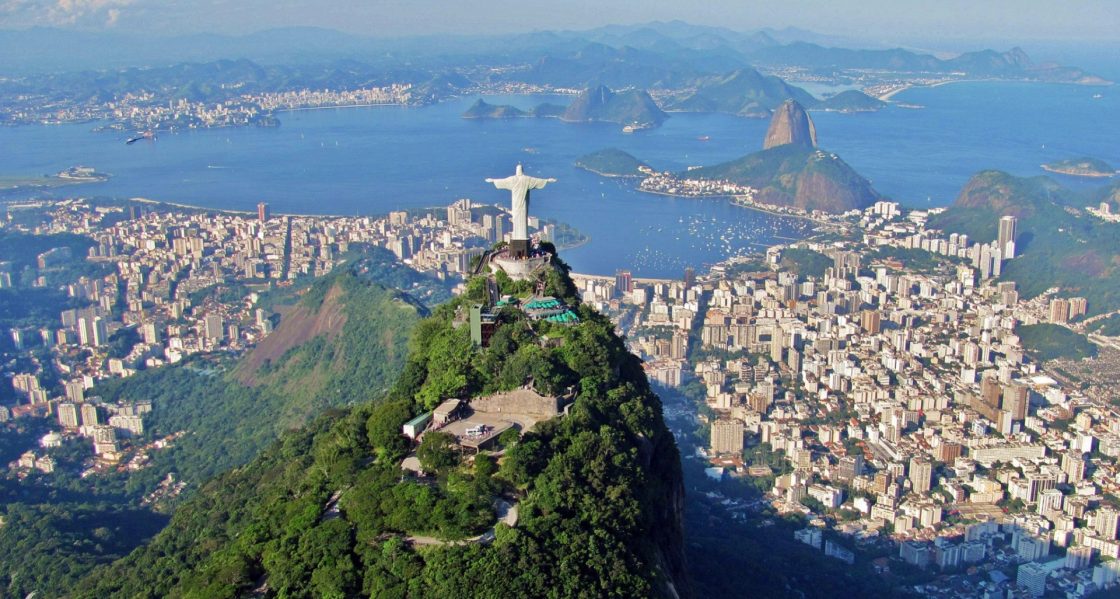Imagem aérea mostra a cidade do Rio de Janeiro. Em destaque está a estátua do Cristo Redentor