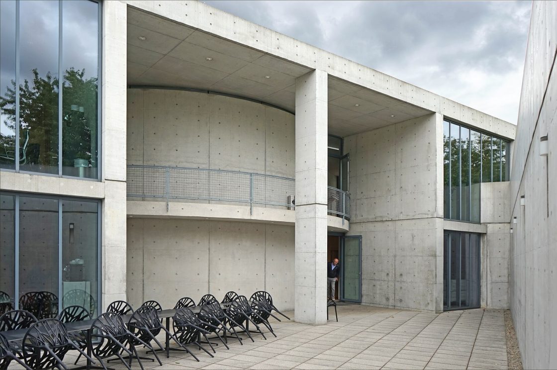 Vista do No projeto do Pavilhão de Conferências da Vitra com diversas cadeiras, em Weil am Rhein, Tadao Ando.