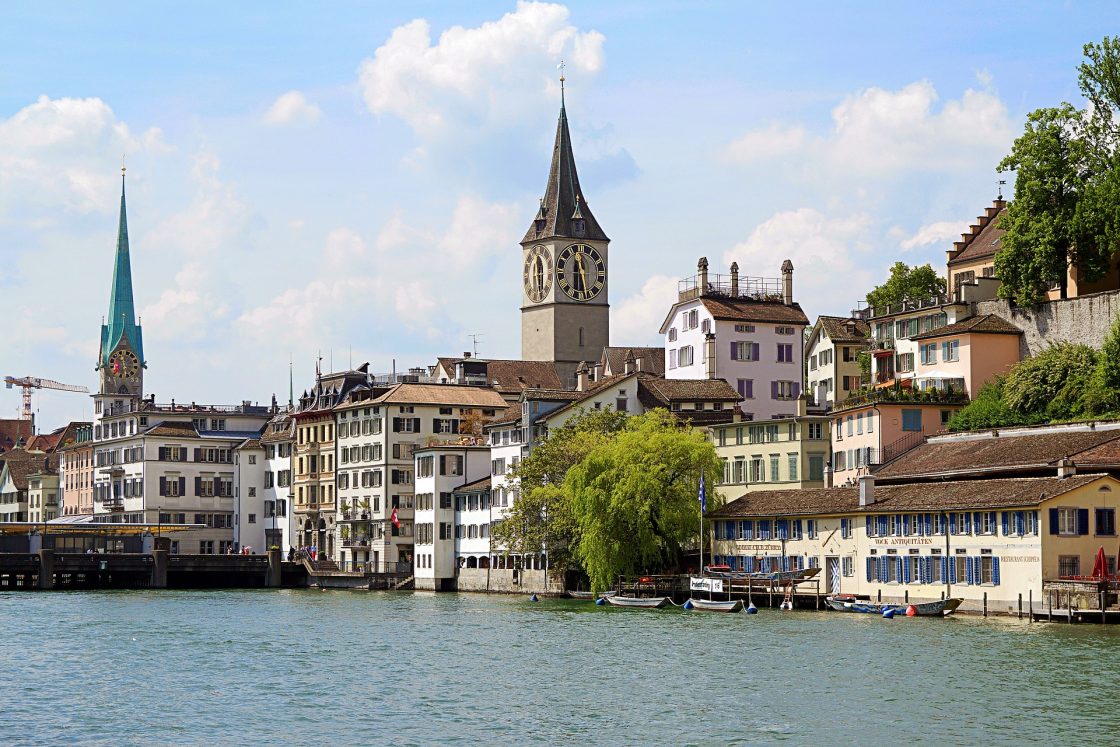 Vista da cidade de Zurique, às margens do rio Limmat, com construções ao fundo