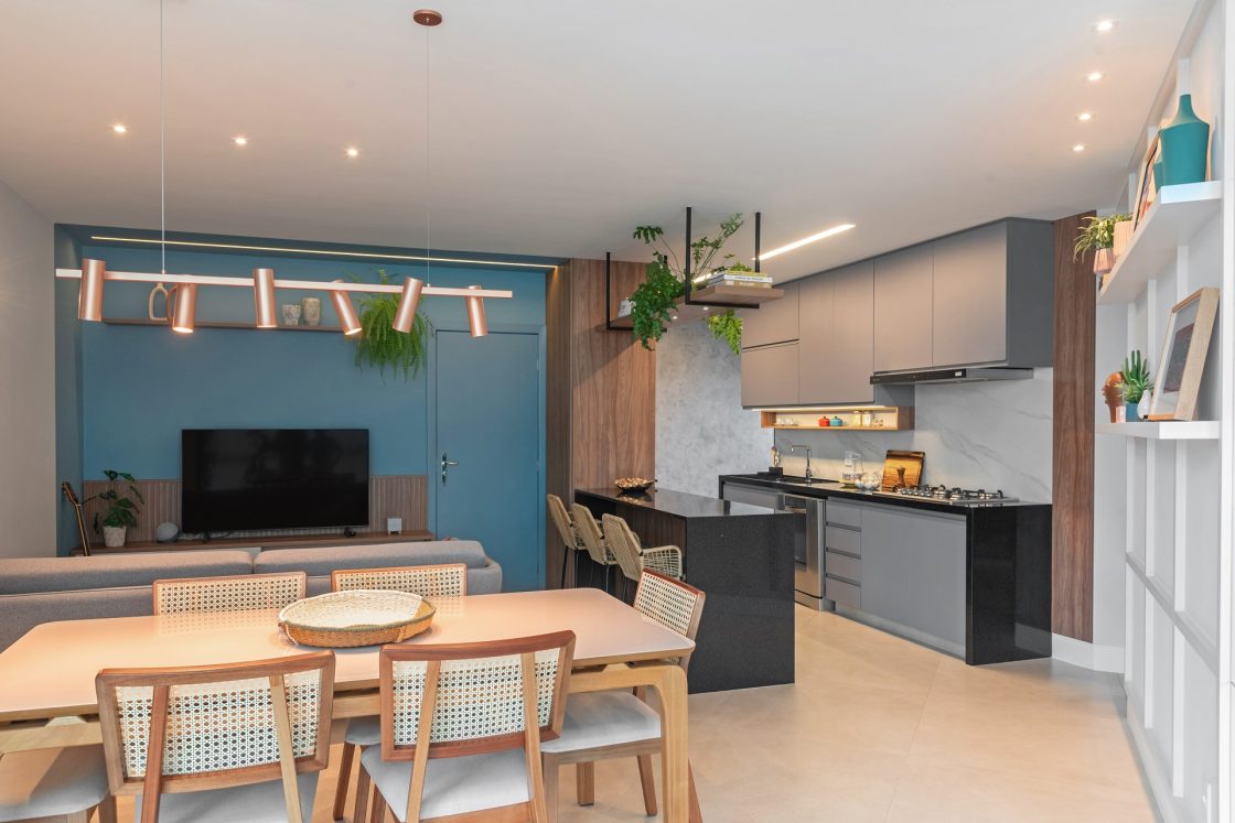Cozinha e sala de jantar integradas em ambiente neutro, com destaque para a parede azul da porta