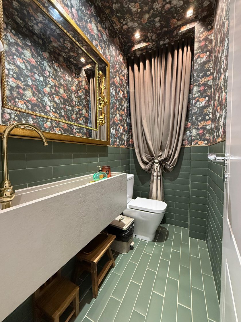 lavabo com cortina, tijolos verde e papel de parede com estampa de flores