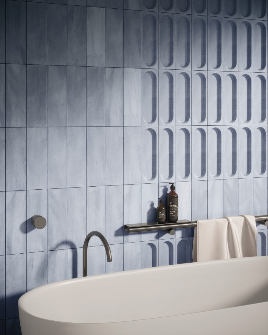 Detalhe de banheiro com banheira branca em frente a uma parede com revestimentos azuis