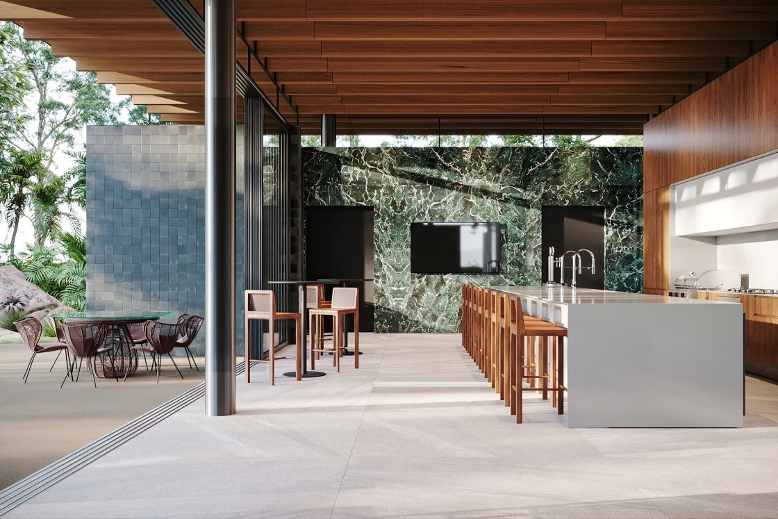 Área gourmet com forro e parede em madeira de reflorestamento, bancada de porcelanato cinza e fundo verde integrado com a paisagem