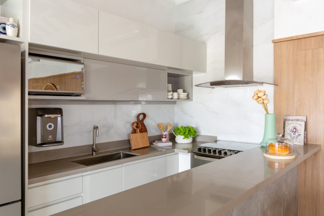 Cozinha clean com bancada, revestimento marmorizado e armários