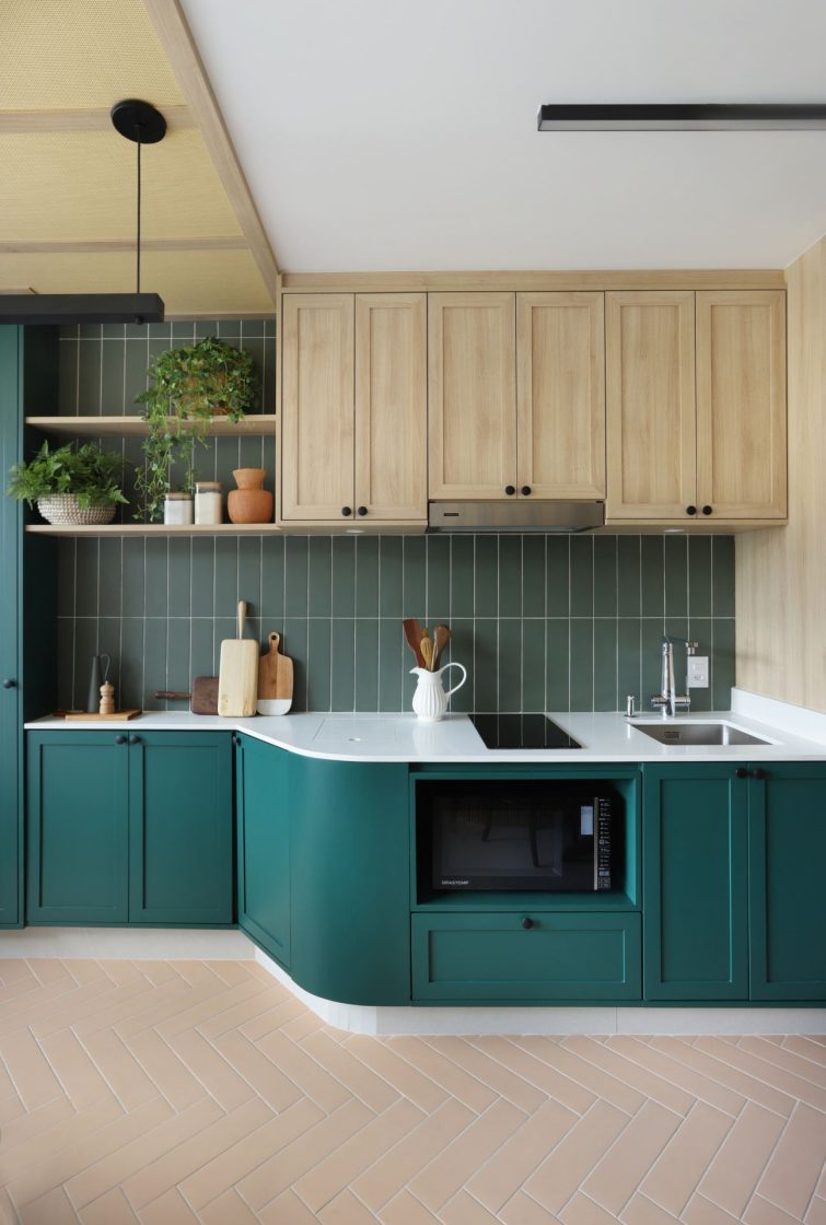 Cozinha planejada com armários em madeira natural e verde escuro, revestimentos de tijolinhos verdes