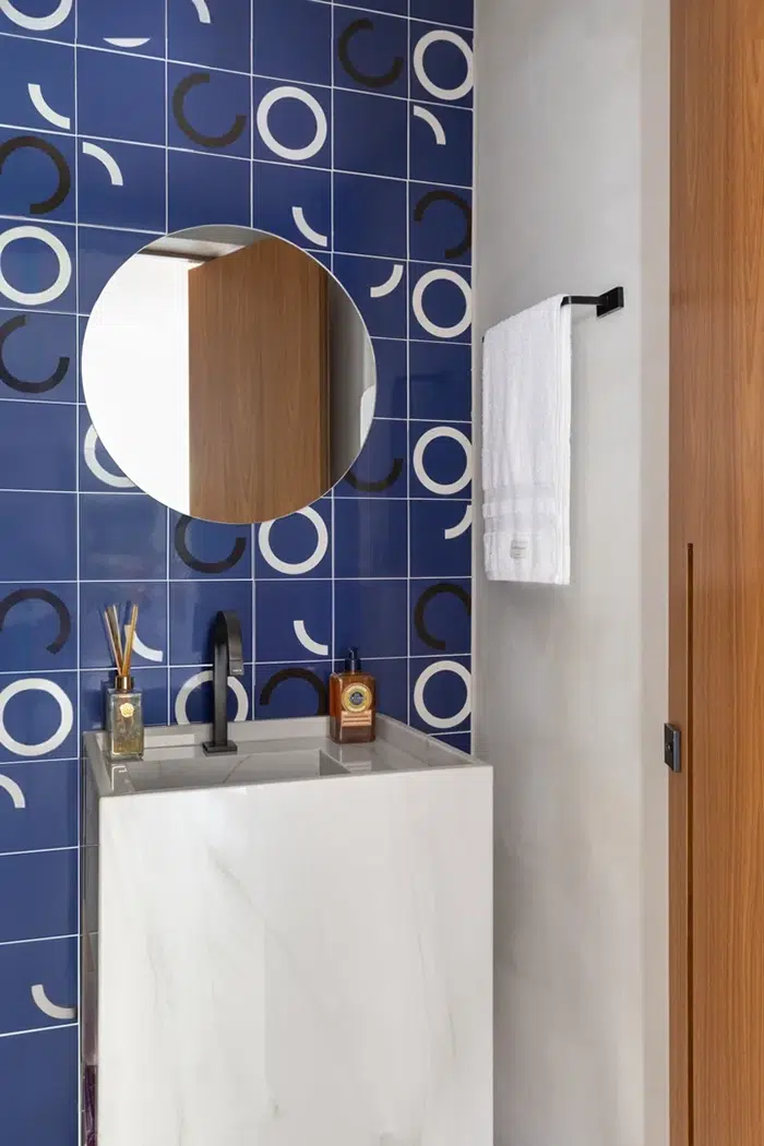 Banheiro moderno com azulejos geométricos mostrando pia e torneira