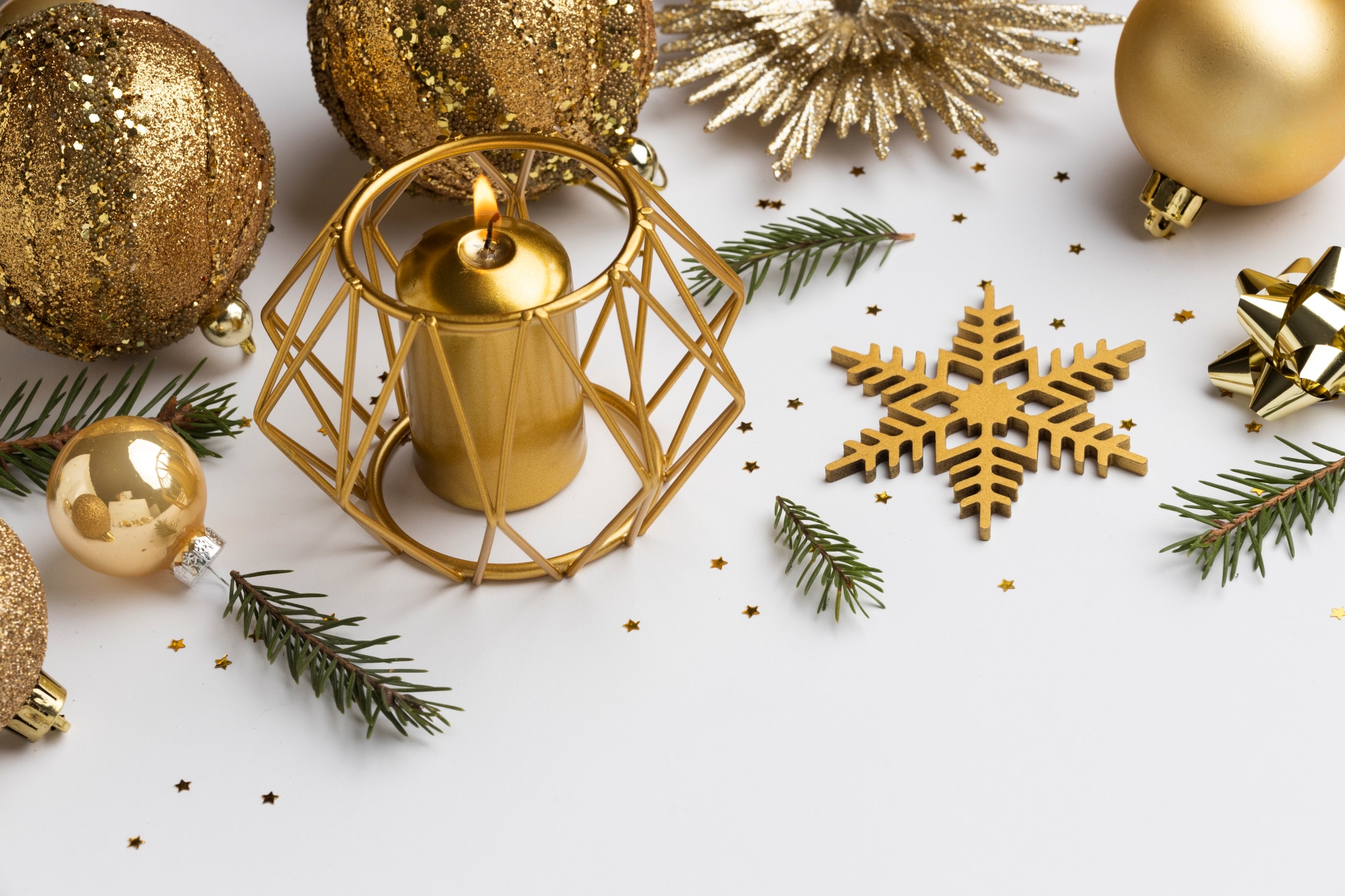Elementos dourados decoração de natal, galhos verdes, bolas de natal, vela, floco de neve e estrela