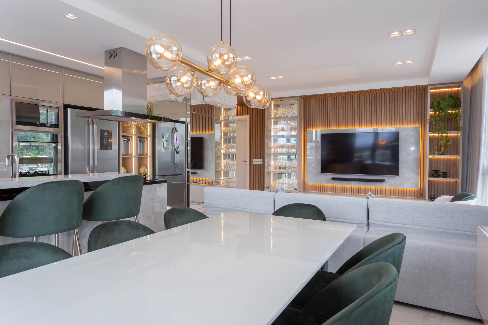Cozinha e sala integradas, com base em tons neutros e detalhes em verde