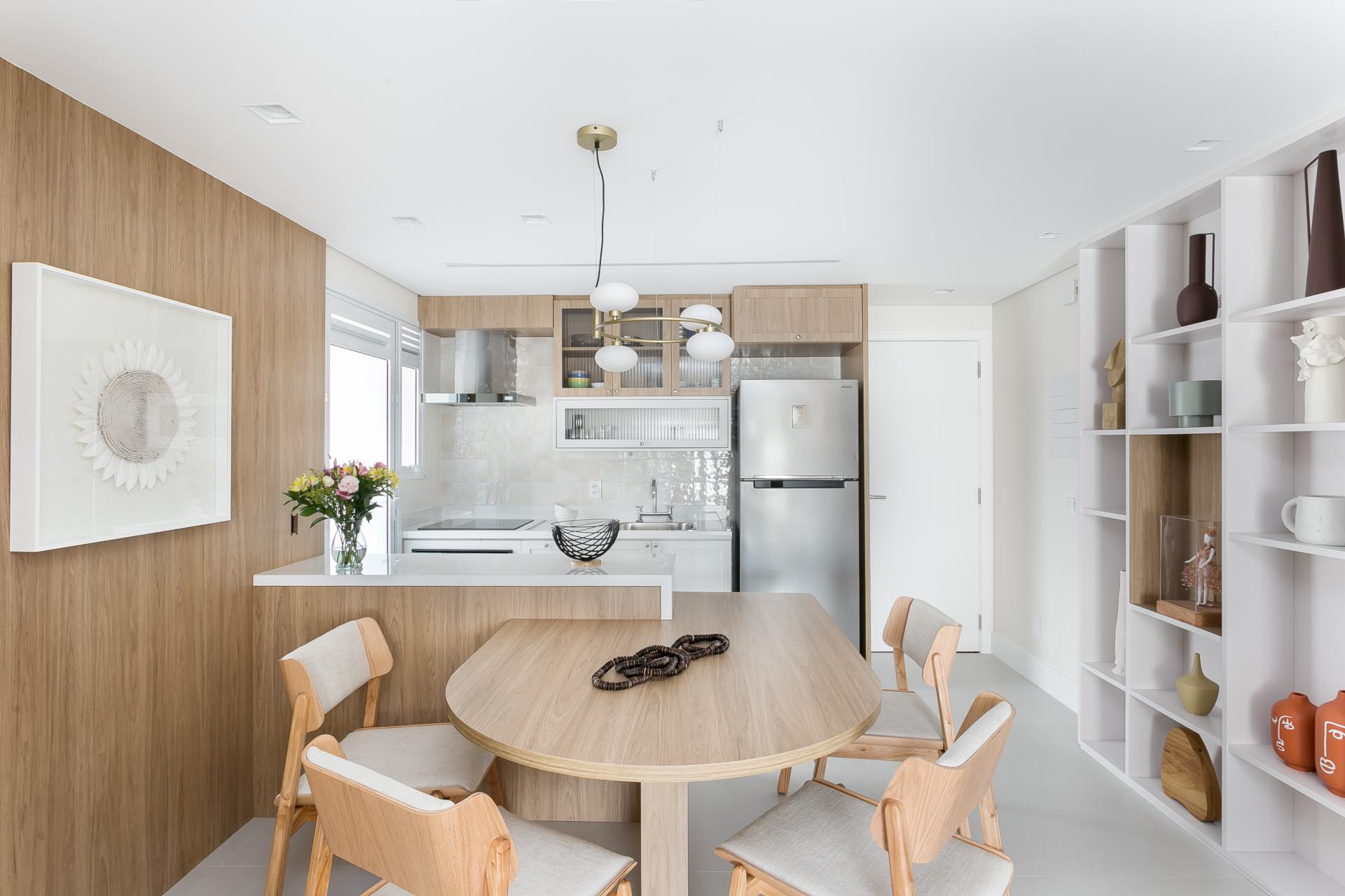 Cozinha e sala integradas, com base branca e detalhes em madeira