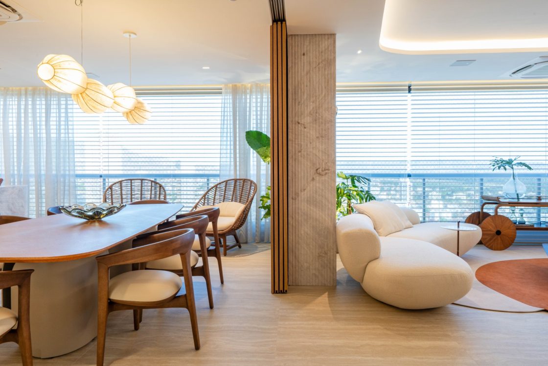 Sala de jantar integrada ao living de apartamento com piso que reproduz travertino