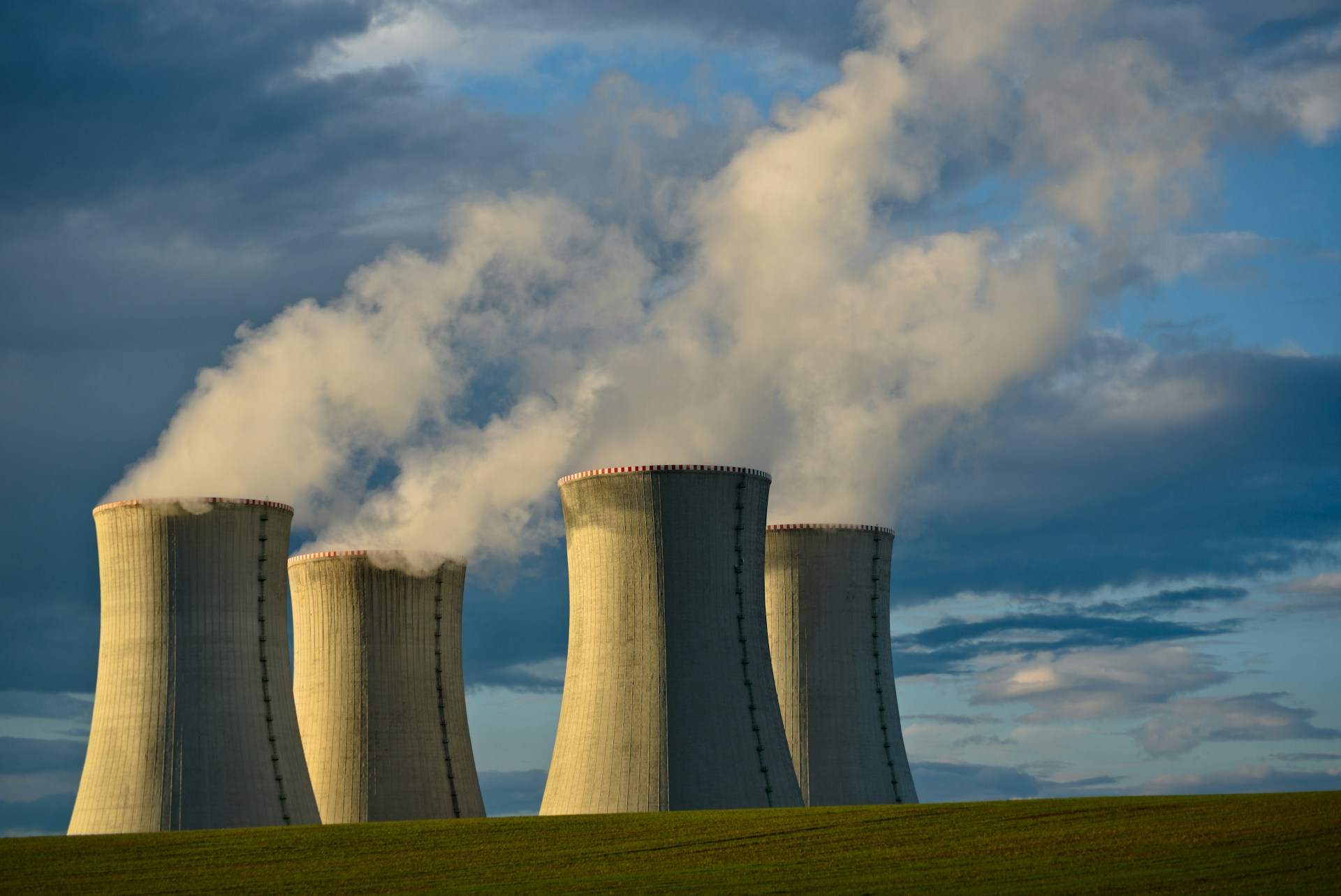 quatro chaminés de uma usina nuclear ocupam a paisagem e soltam vapor