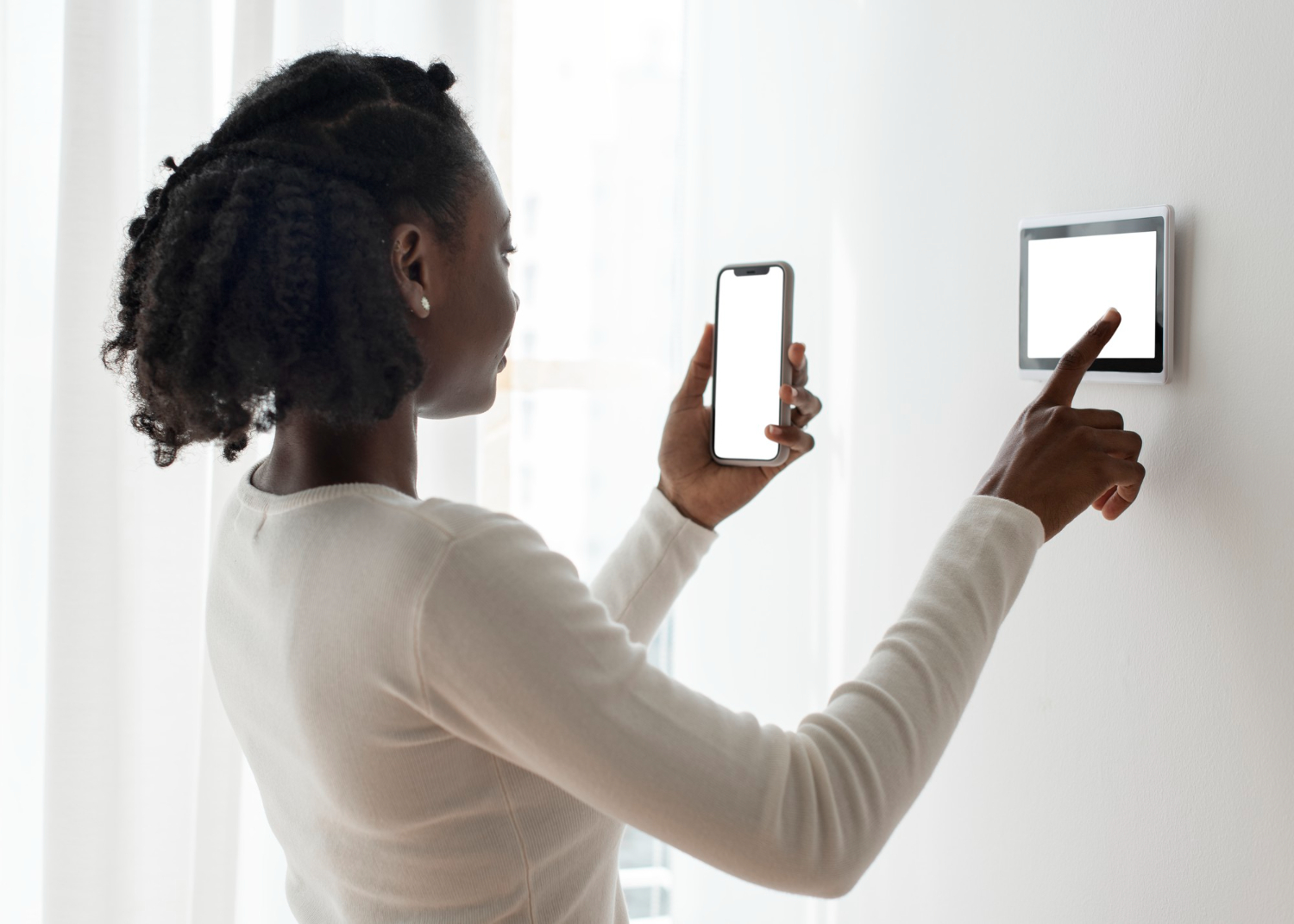 Mulher segurando smartphone e utilizando uma tela de controle de automação residencial