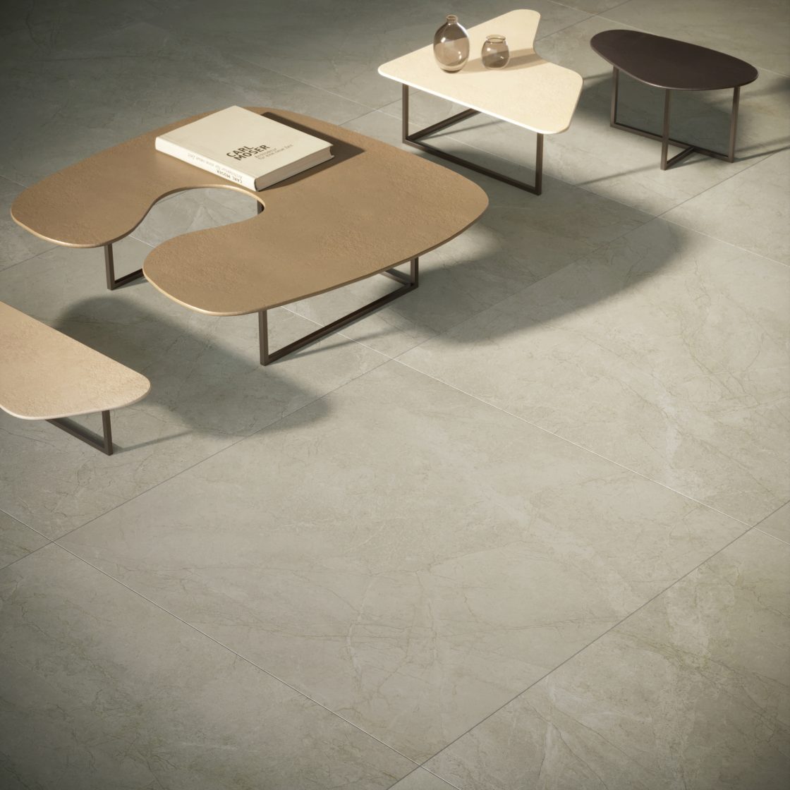 Área com revestimento que reproduz mármore no piso e quatro mesas com formatos orgânicos