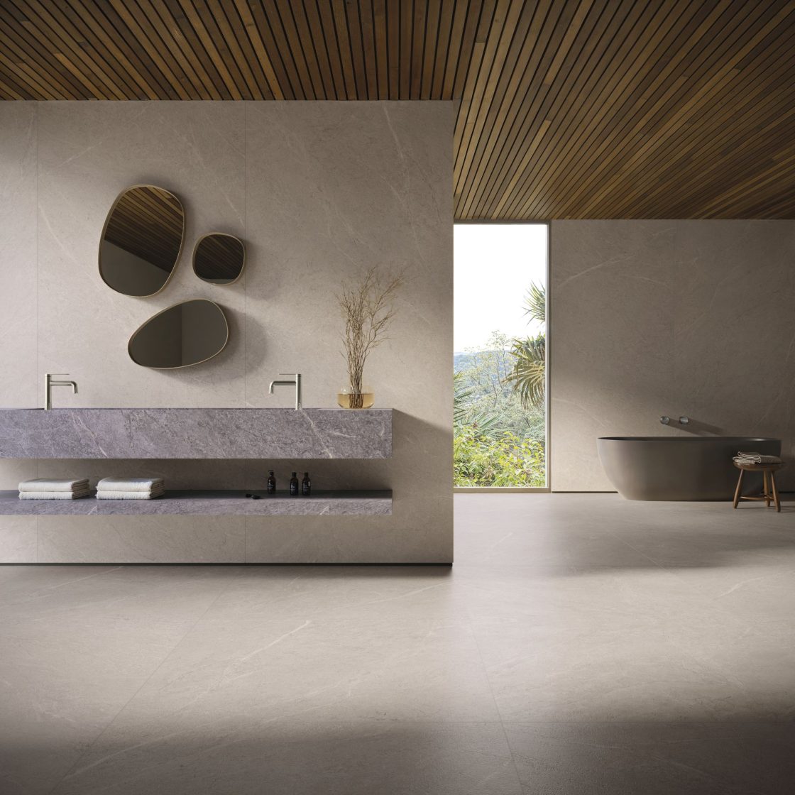 Banheiro com porcelanato natural no piso, com banheira de imersão ao fundo e bancada com revestimento em porcelanato cinza