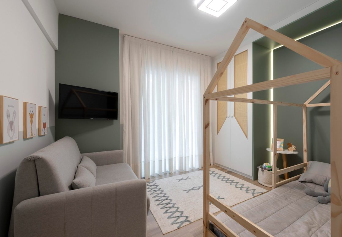 Quarto infantil com decoração safari, em tons de verde e madeira