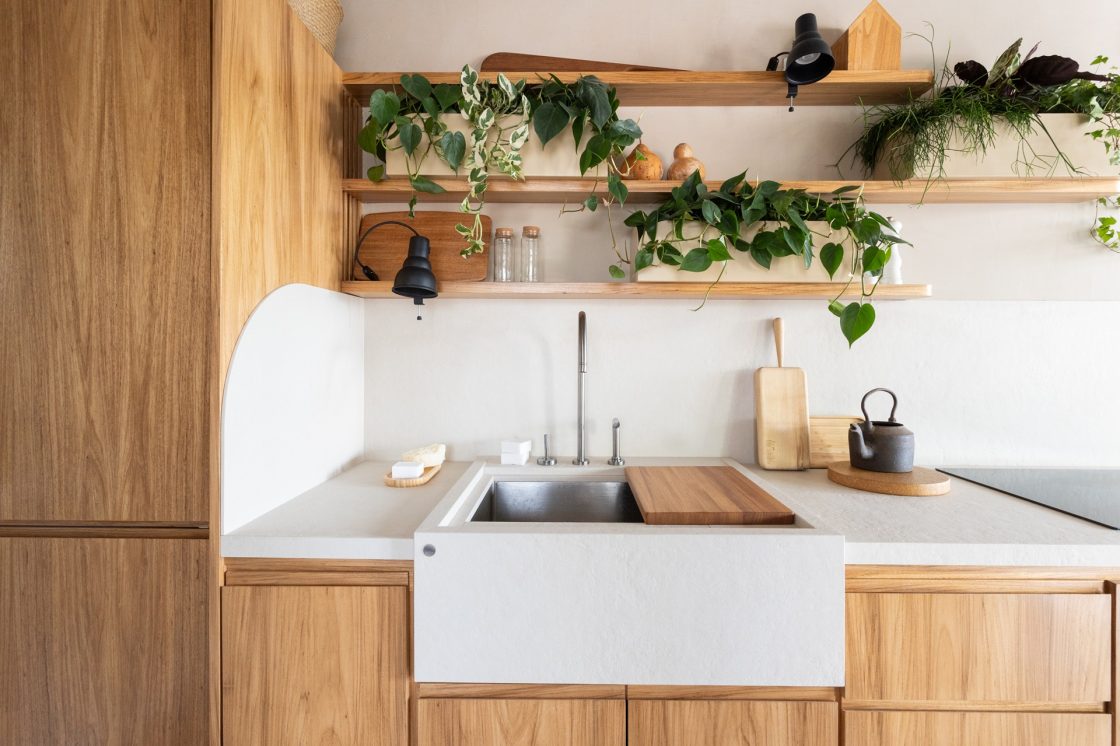 Frontão em cozinha com móveis de madeira e bancada em porcelanato claro