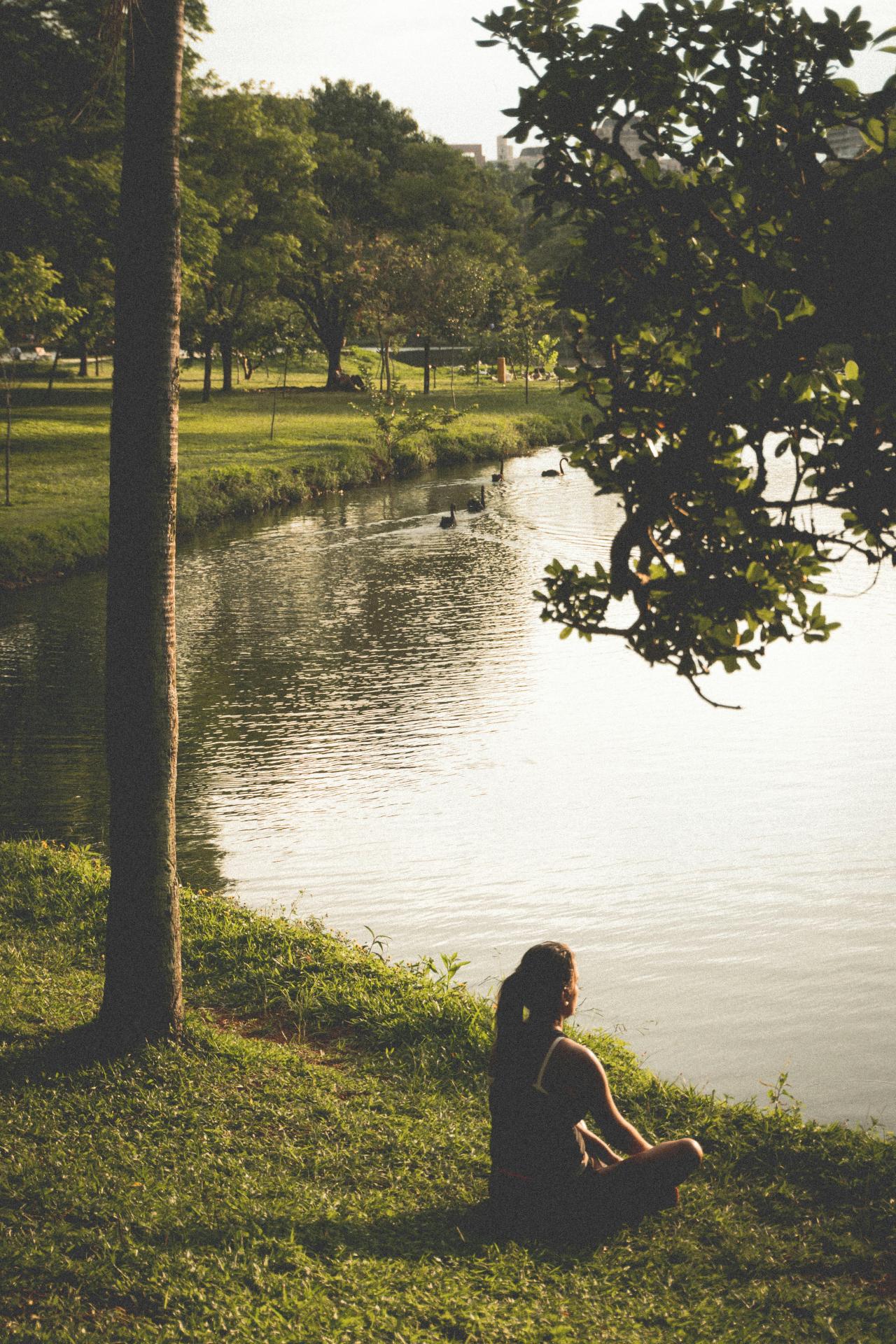 Mulher sentada na beira do lago