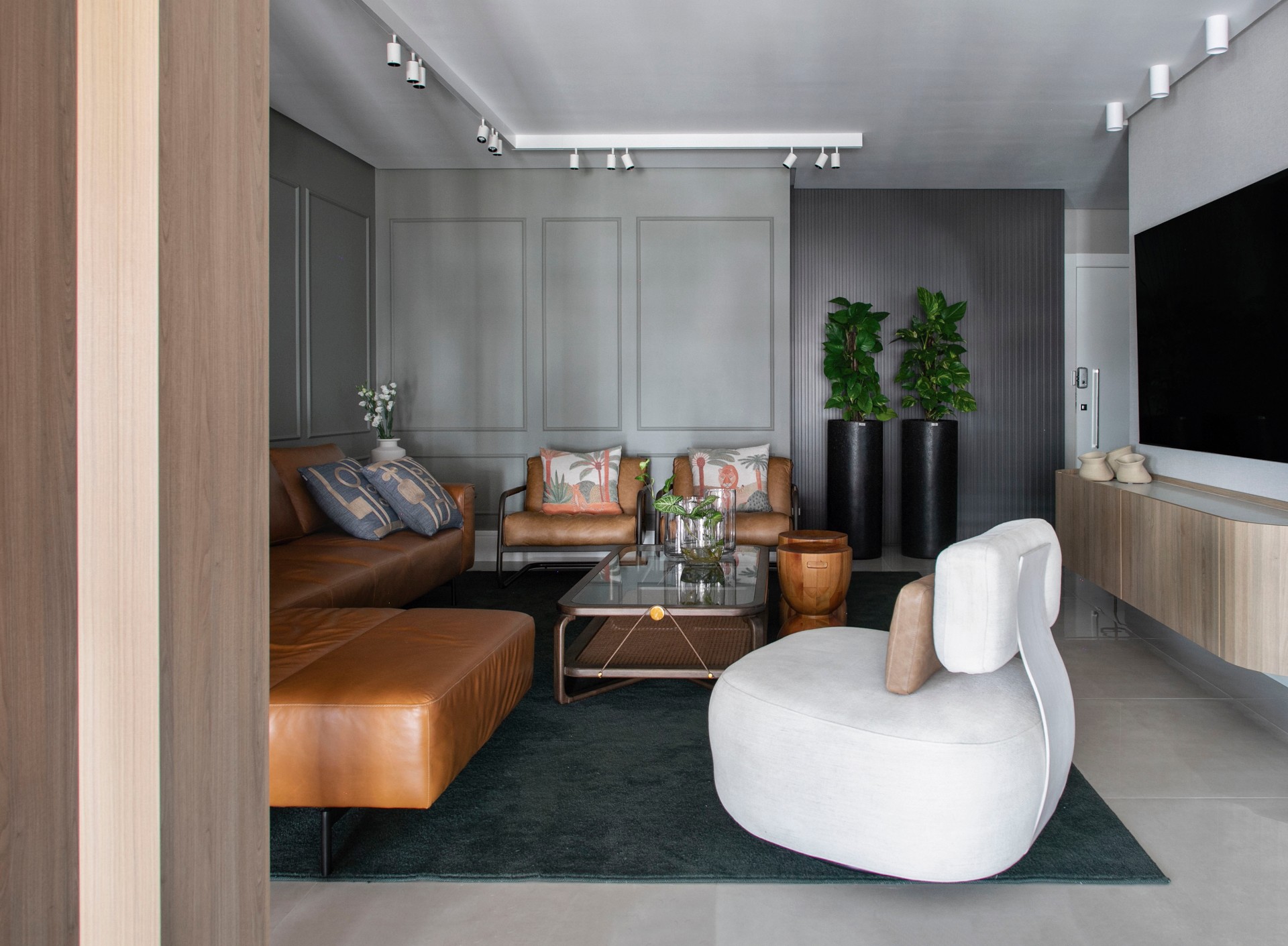 Sala de estar com sofa de couro e poltrona branca