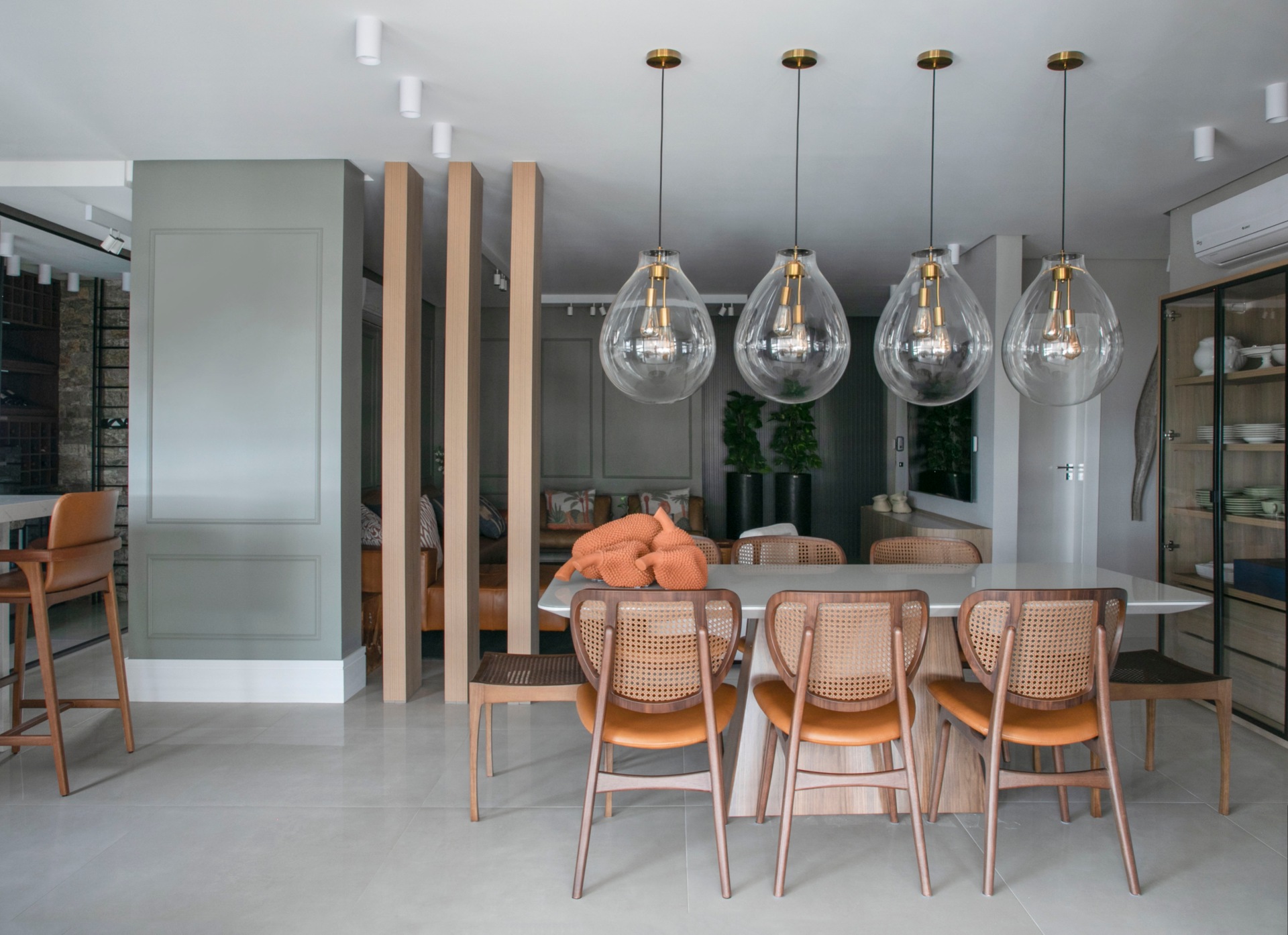 Sala de jantar com mesa e luminárias pendentes de vidro