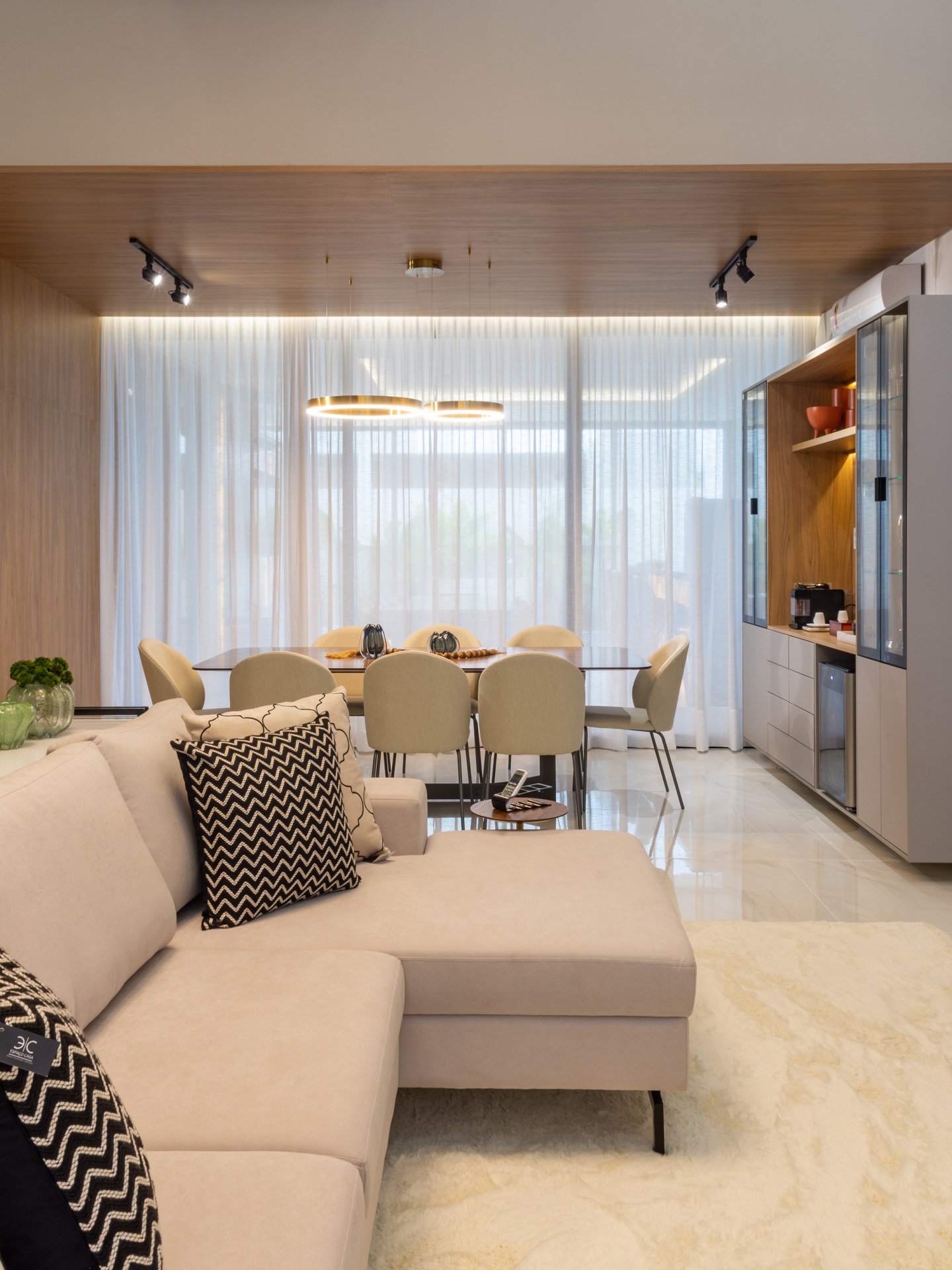 Sala de estar e jantar integradas, em tons neutros, com detalhes em mármore e madeira