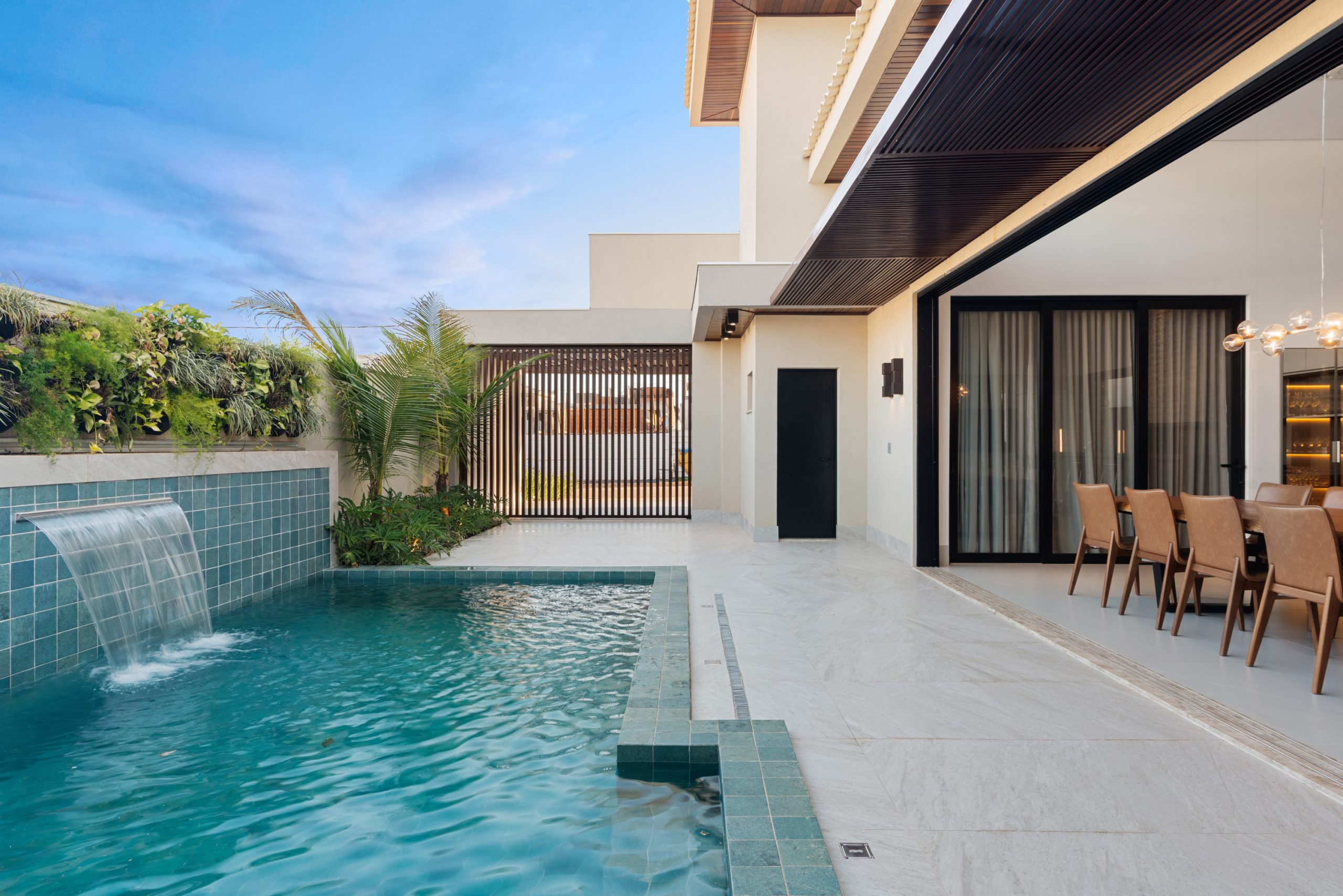 área externa da casa com piscina azul e porcelanato 80x80