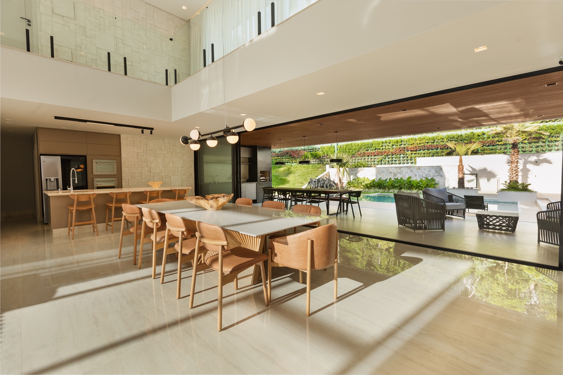 Ambiente amplo, com cozinha e sala de jantar integradas à área externa com piscina