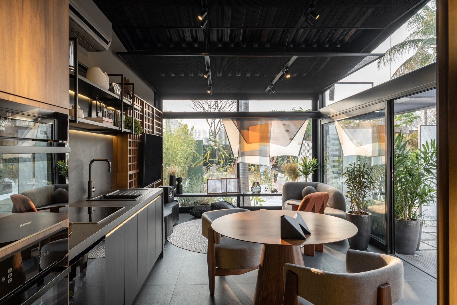 Casa pequena com ambientes integrados e decoração com predominância do preto e da madeira
