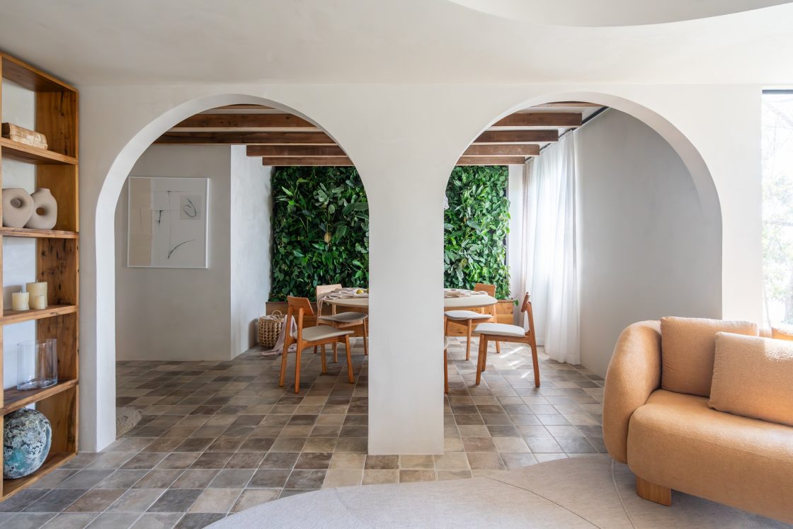Sala de estar e jantar integradas em estilo mediterrâneo, com arcos, paredes brancas e tons terrosos