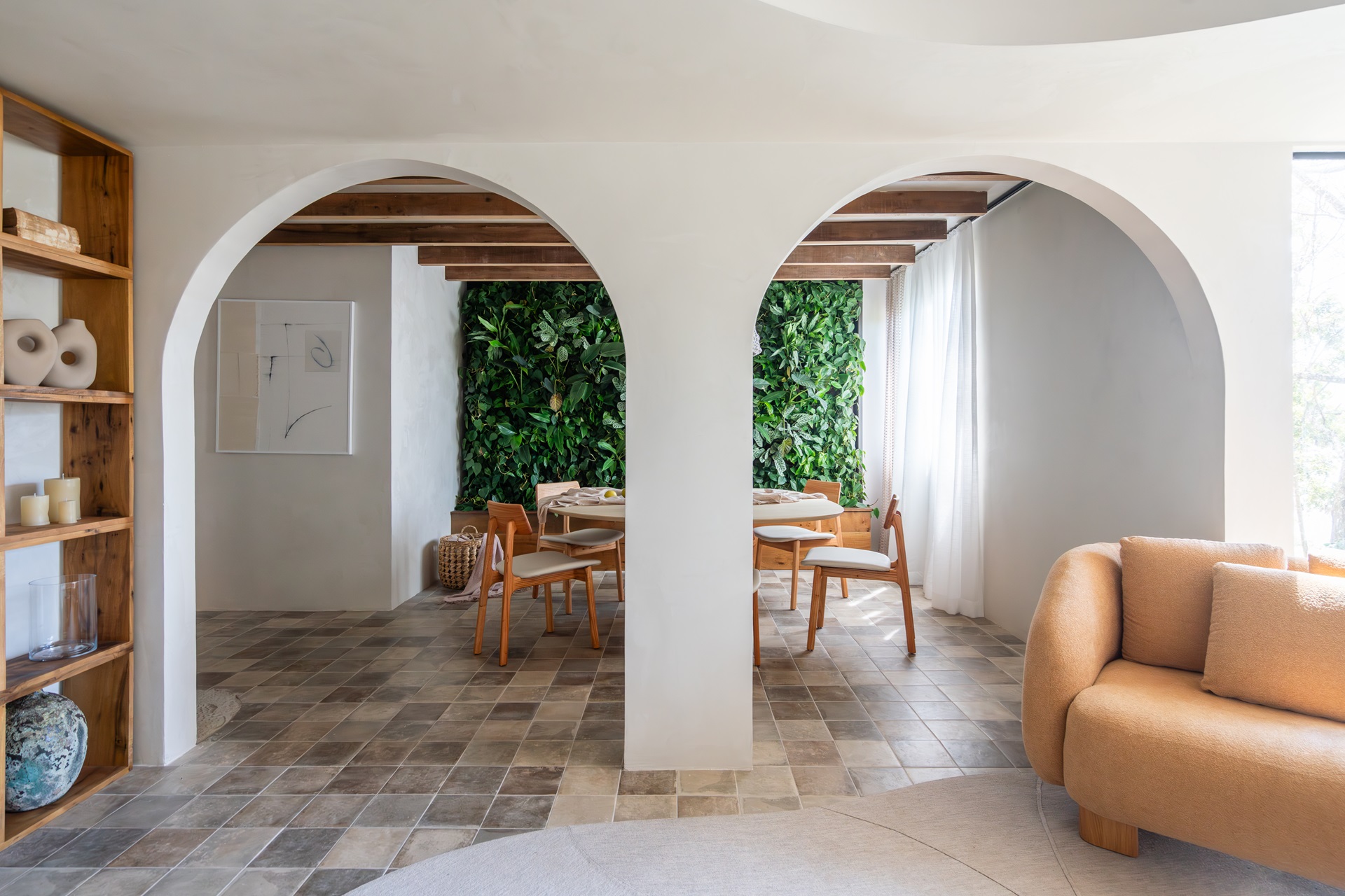 Sala de estar e jantar integradas em estilo mediterrâneo, com arcos, paredes brancas e tons terrosos