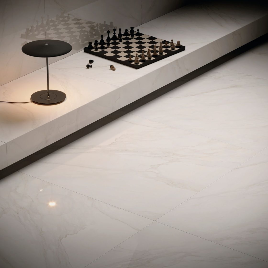 Piso em porcelanato que reproduz mármore carrara. Há uma mesinha e um tabuleiro de xadrez sobre ele