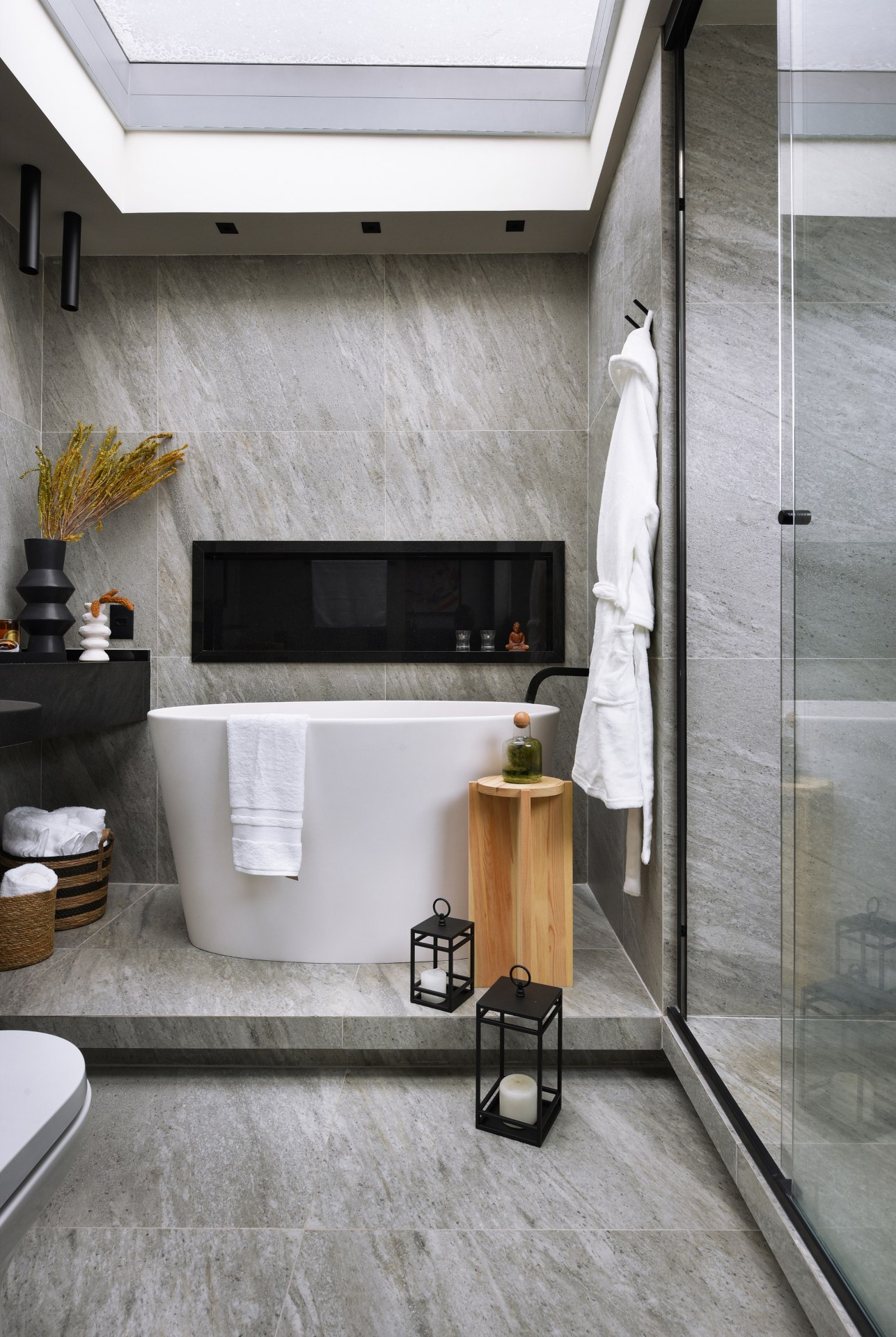 Detalhe de banheiro com banheira, nicho e objetos decorativos. Ele tem jeito de SPA