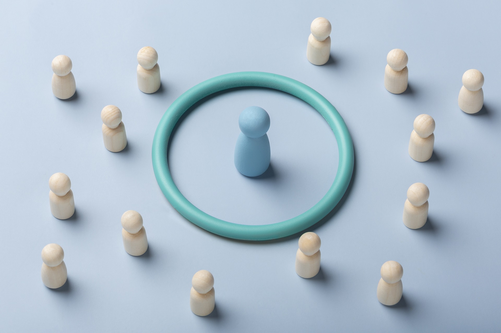 A imagem representa o conceito de público-alvo. Há um boneco em azul e, ao redor dele, há um círculo. Os demais bonecos são brancos