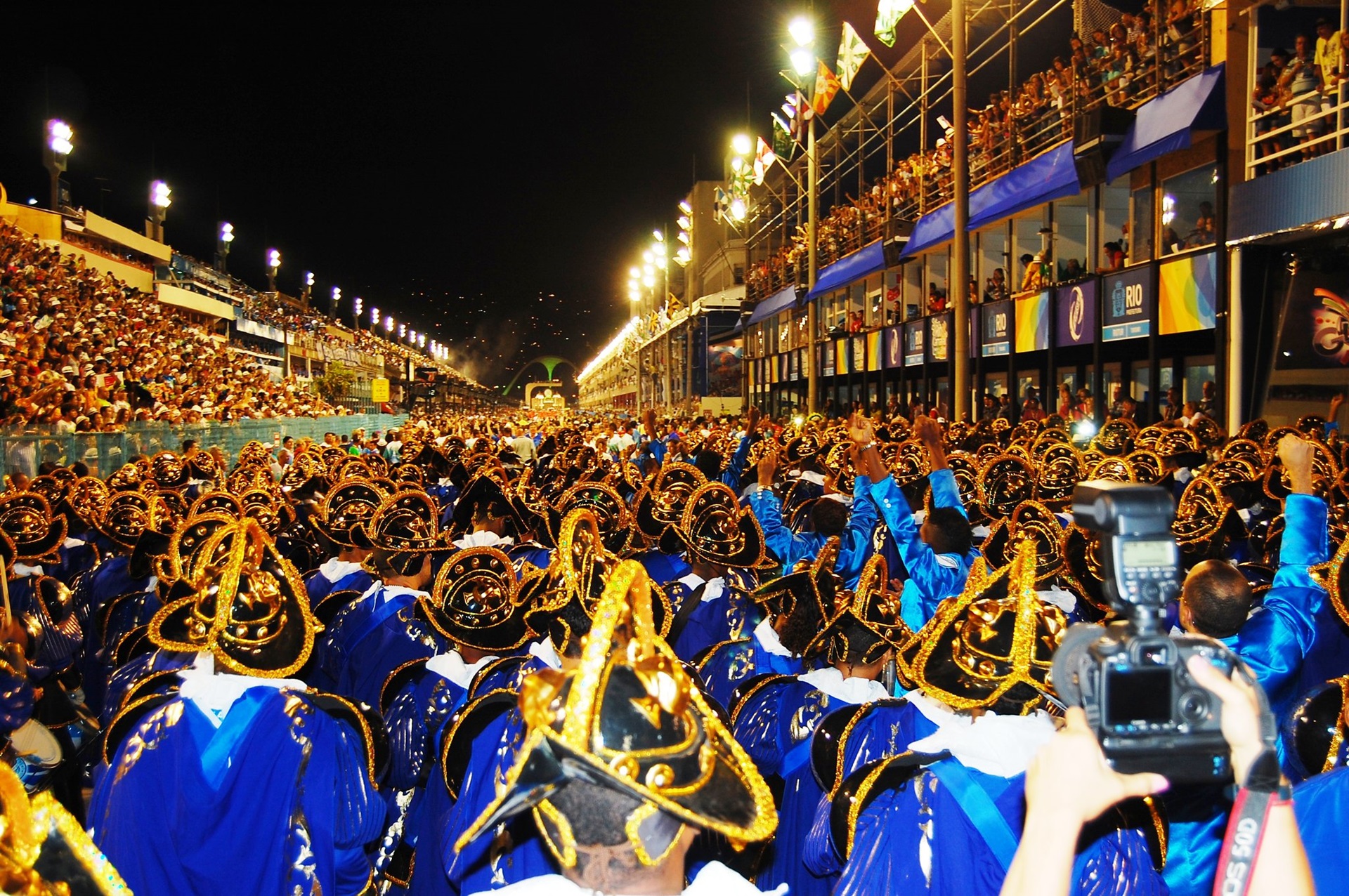 Visão de uma das alas de uma escola de samba durante desfile à noite