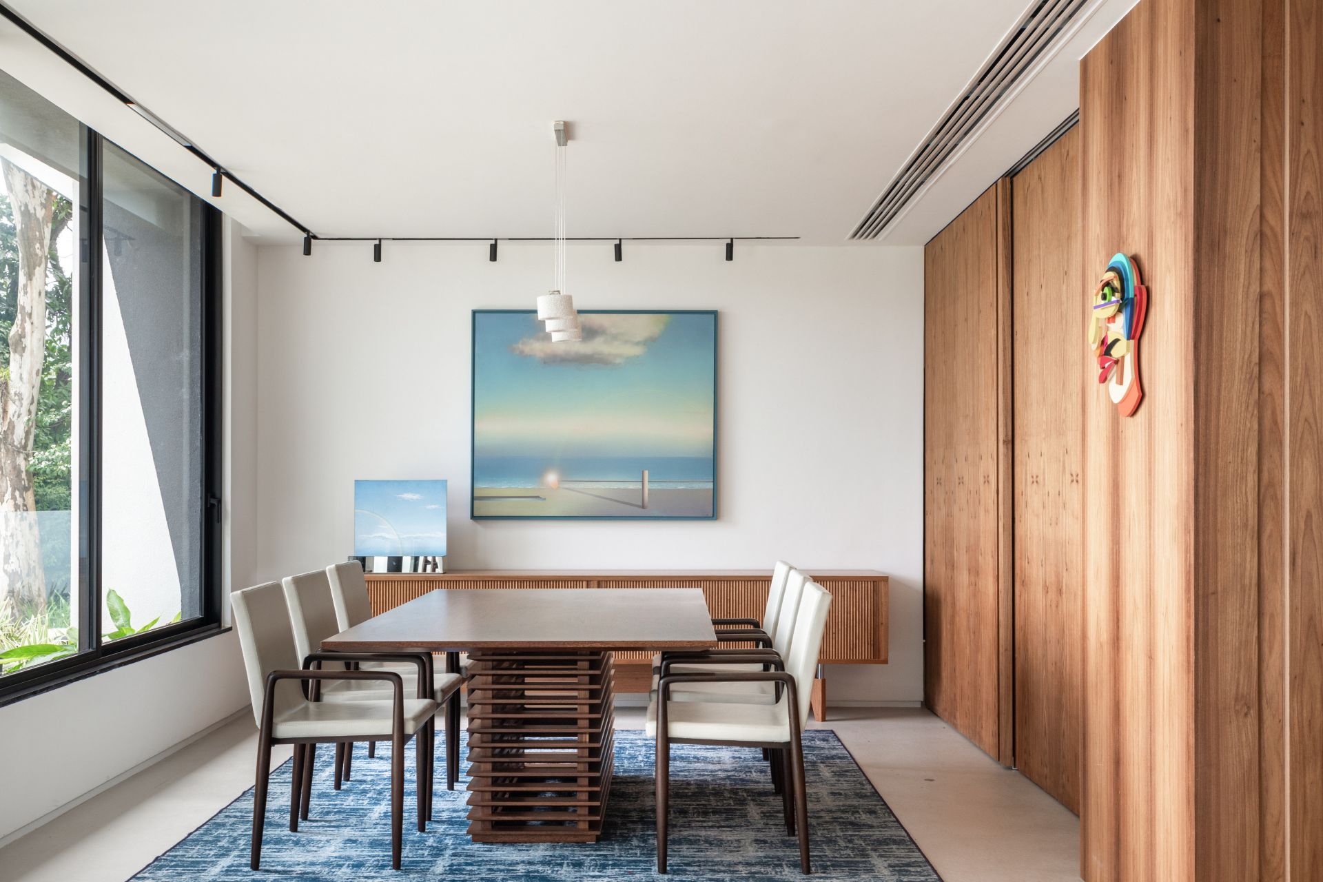 Sala de jantar com mesa grande e quadro pendurado na parede ao fundo