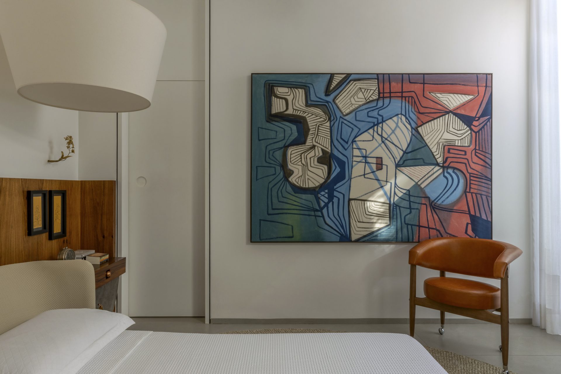 Quarto de casal com quadro na parede paralela à cama