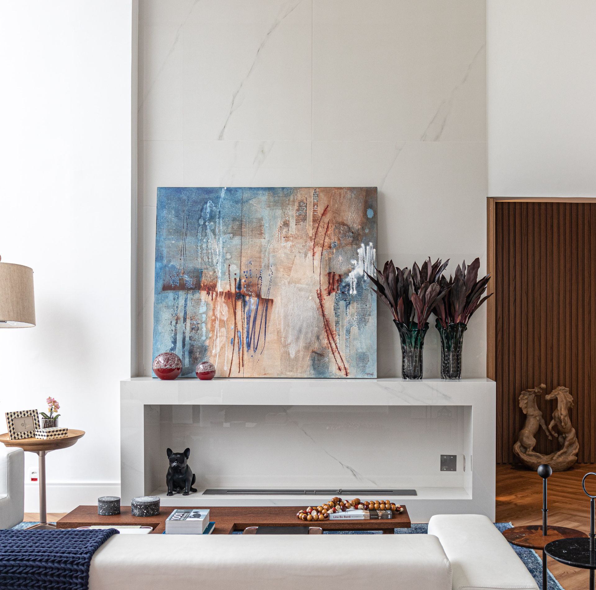 Detalhe de sala, com lareira e quadro logo acima